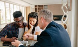 Homebuyers reviewing closing documents with advisor - ALTA SURVEY Kentucky Homebuyers reviewing mortgage surveys and closing paperwork with a real estate advisor