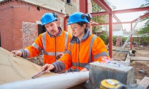 Surveying companies reviewing site plans with construction team during development review on a building site