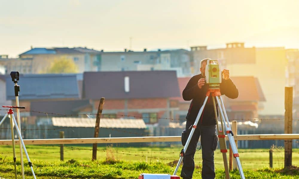 Surveyor performing a boundary survey in a Bowling Green,residential area to confirm property lines for HOA approval