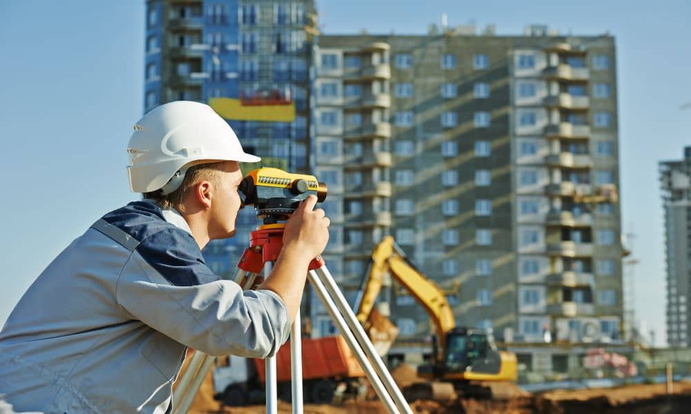 Commercial property survey bowling green - ALTA SURVEY Kentucky Professional land surveyor using a total station at a commercial construction site to ensure accurate parking lot and property surveying in Bowling Green