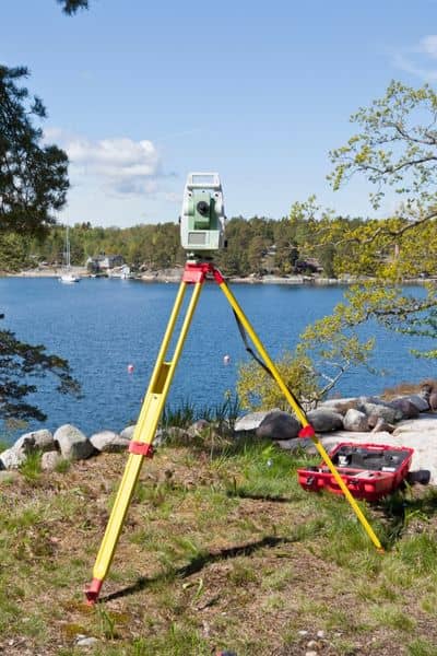 Land survey equipment near water elevation measurement - ALTA SURVEY Kentucky Surveying equipment set up near a river to measure land elevation and collect data for a flood elevation survey