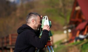 Residential land surveyor measuring home elevation - ALTA SURVEY Kentucky Licensed land surveyor measuring home elevation for a FEMA elevation certificate