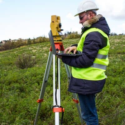 Surveyor using total station - ALTA SURVEY Kentucky Surveyor collecting field measurements with total station during an early construction survey