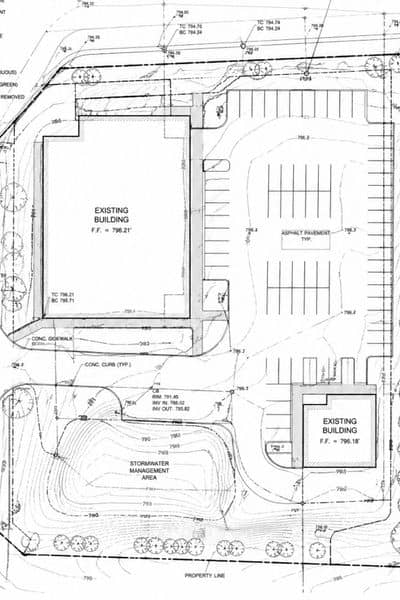 Technical site plan showing building layout, elevations, and existing site features for survey mapping