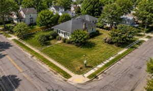 Older corner lot property lines land survey - ALTA SURVEY Kentucky Older suburban corner lot with property boundary lines and a land surveyor using GPS equipment to locate property lines at a two-street intersection