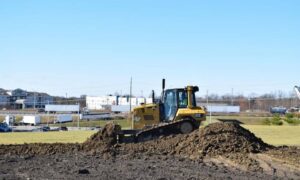 Bulldozer grading soil for a raised commercial building pad
