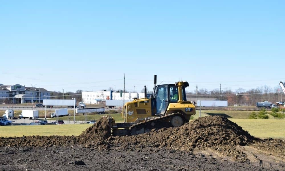 Bulldozer grading soil for a raised commercial building pad