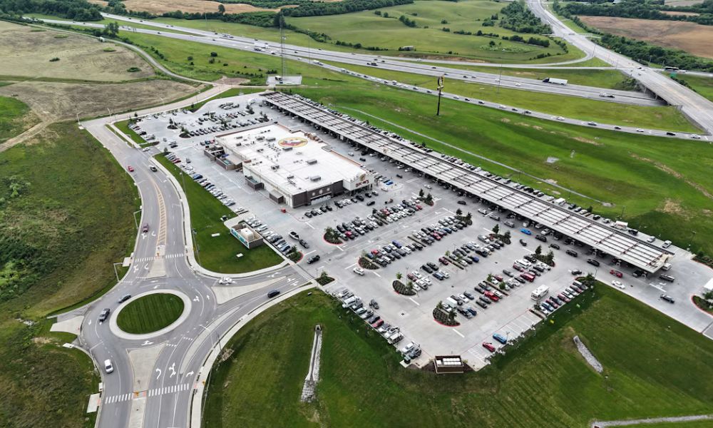 Aerial view of a commercial property with parking areas, access roads, and surrounding open land